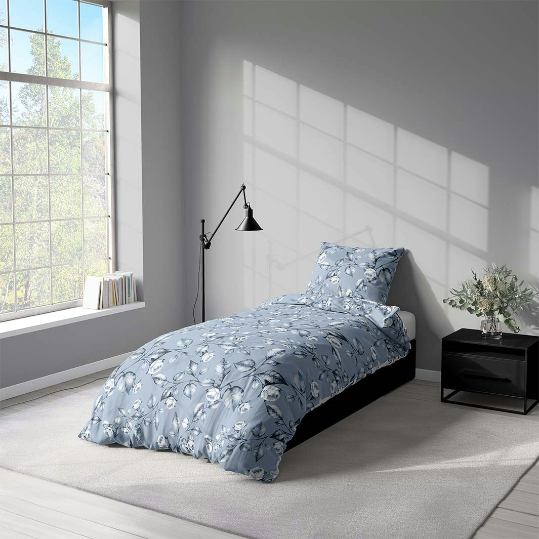 Aurora blue ett påslakanset i bomull i ljusblått med blå och vita blommor med knäppning i botten, från Indusia design
