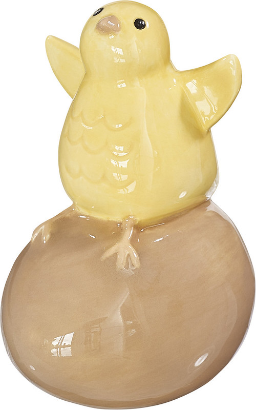 Cult design Brunettas tös är en söt påskkyckling som sitter på ett ägg och flaxar med vingarna i glaserad lergods