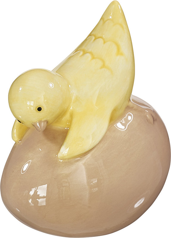 Cult design Brunettas tös är en söt påskkyckling som ligger på ett ägg och myser, i glaserat lergods