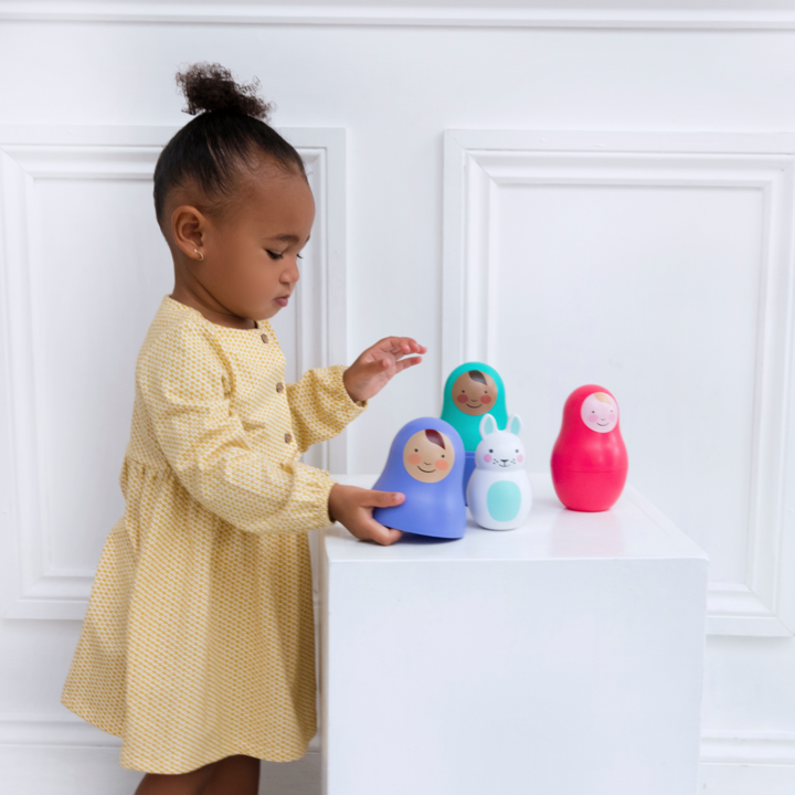 Flicka som leker med Rosa & Bo dockor i olika färger