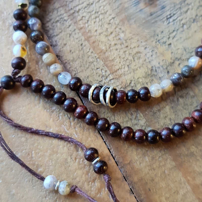 Armband med små pärlor av mörk sandelträ & agat i jordnära nyanser, tre små hamrade silverringar som detalj.