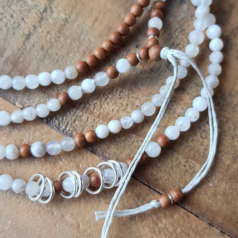Långt halsband med små pärlor av ljus agat & ljus sandelträ som harmonierar fint med sju tunna silverringar som leker fritt på halsbandet.
