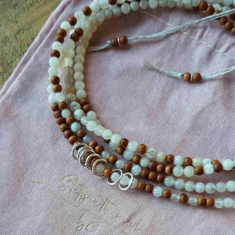 Halsbandet skickas i fin ljusrosa smyckepåse av eco-bomull.