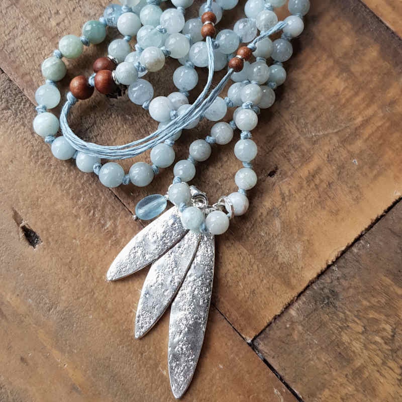 Mala halsband med pärlor av akvamarin i mjuka ljust blå nyanser.