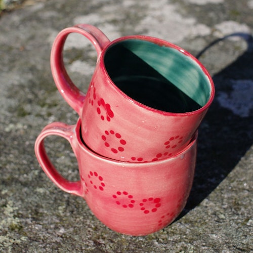 Rosa kaffekopp med røde prikker