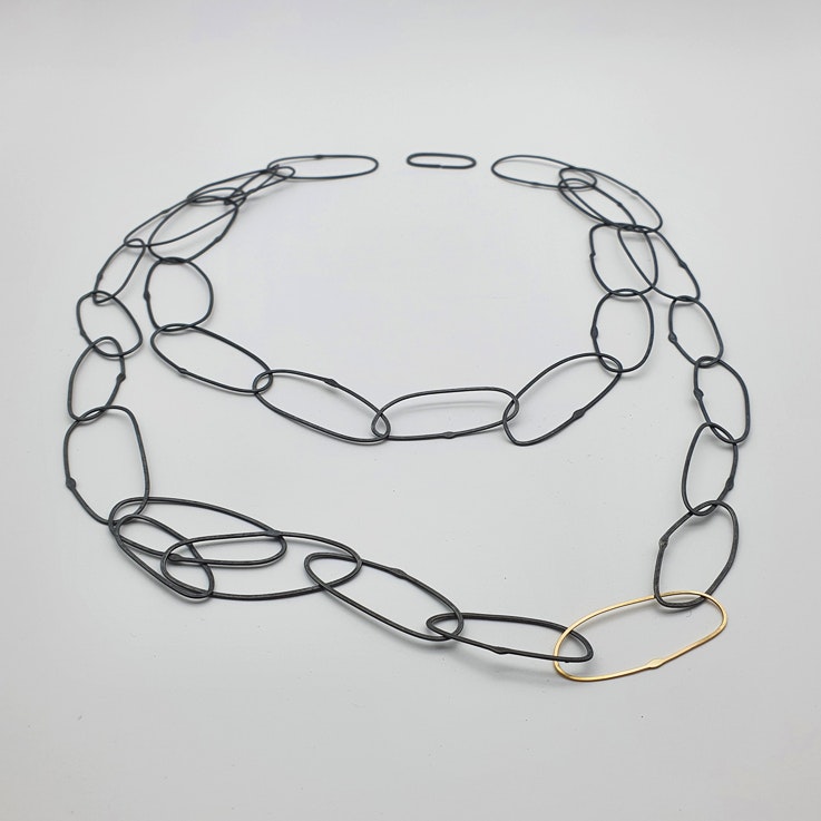 Handgjort halsband med länkar i oxiderat silver samt en länk i 18k guld.