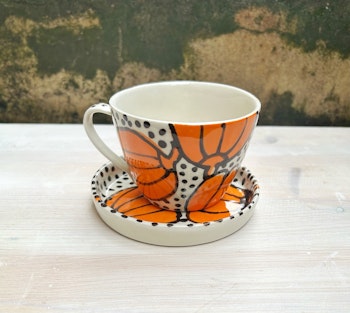 Kopp med fat orange blomma