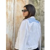 Moon of Bethlehem hand embroidered with love by woman artisan in Jordan on a white denim jacket with long sleeves. Featuring patch pockets on the chest, welt pockets at the waist, belt loops at the ba