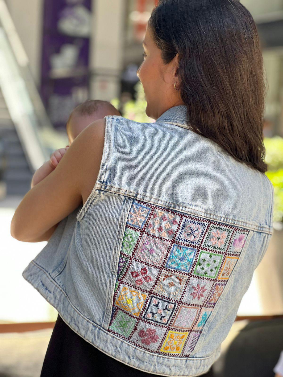 Arabesque denim vest with a V-neckline. Patch pockets with flaps on the front. Metallic button fastening on the front. MATERIAL & SUSTAINABILITY  Material: 100% cotton   Hand embroidered denim vest wi