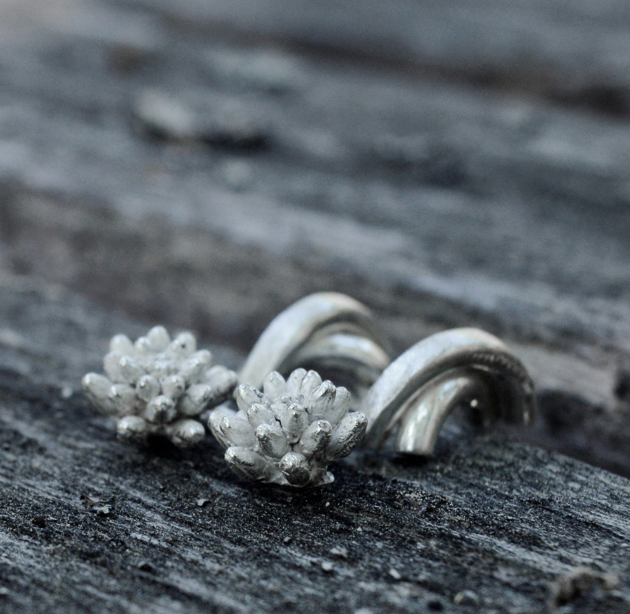 Earrings in 925 sterling silver. Double half rings with a flower approximately 9 mm in diameter, total length approximately 23 mm