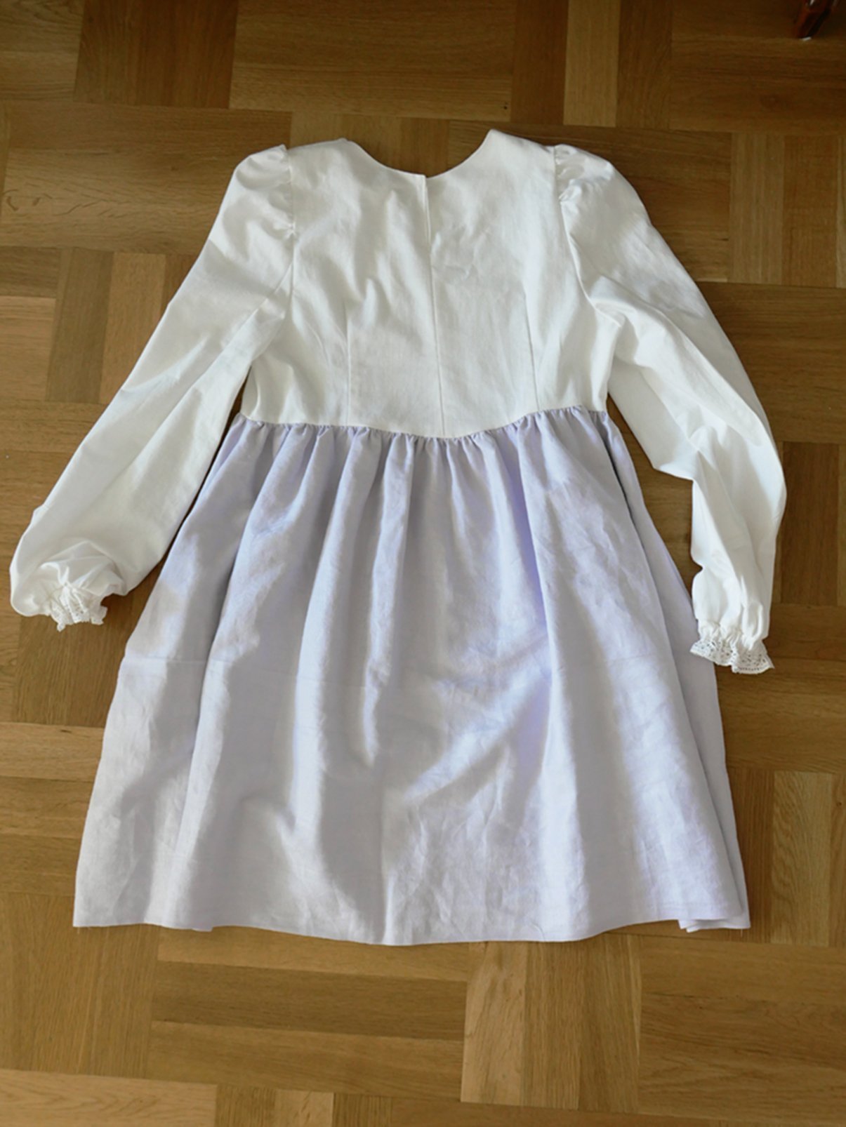 Romantisk och lantlig klänning i vitt och ljuslila med spetsdetaljer