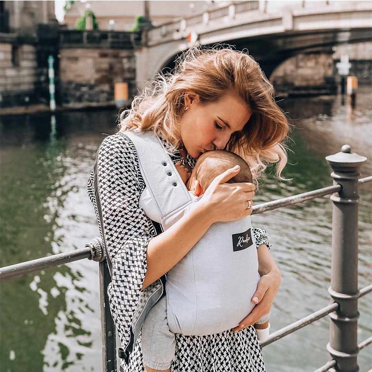 Kvinna som pussar bebis med ROOKIE Premium baby bärsele - Grey