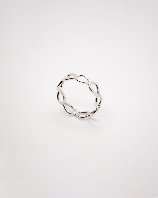 Handtillverkad ring i silver, med halvöglor ihopsatta som små böjda grenar.