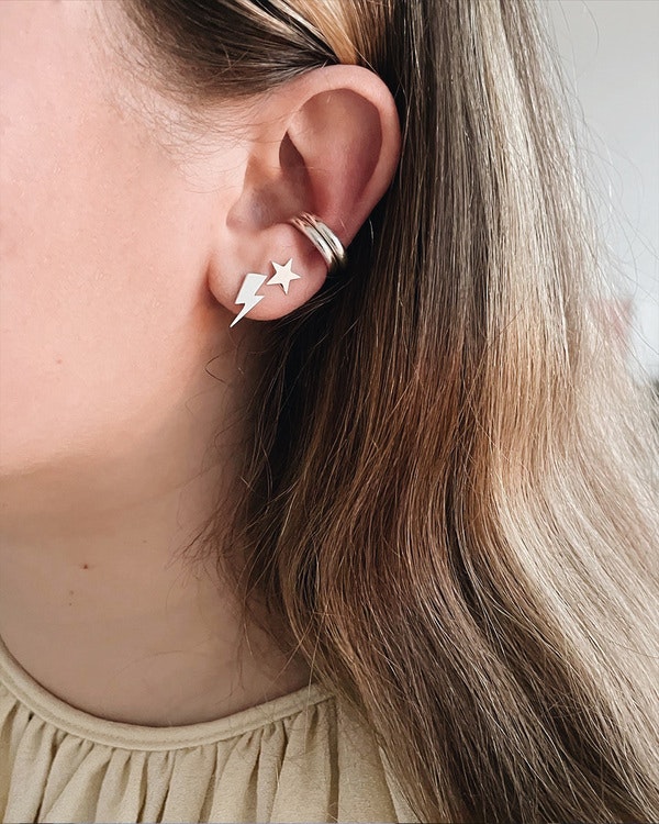 Litet silverörhänge, 10 mm hög blixt som är utsågad för hand. Sitter i örat tillsammans med två earcuffs och en stjärna.