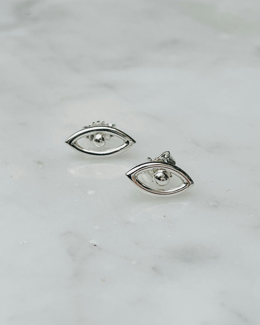Ett par små örhängen med form av ögon. Handgjorda i återvunnet silver.