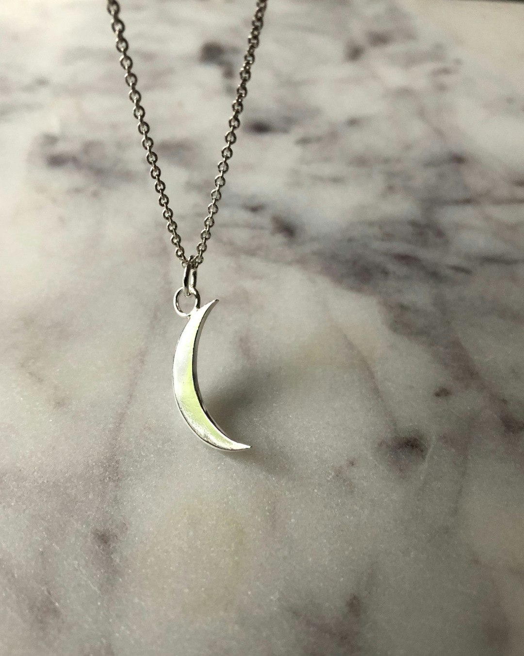 Handgjort halsband i återvunnet silver med en nymåne, 2 cm hög, hänger på en kedja.