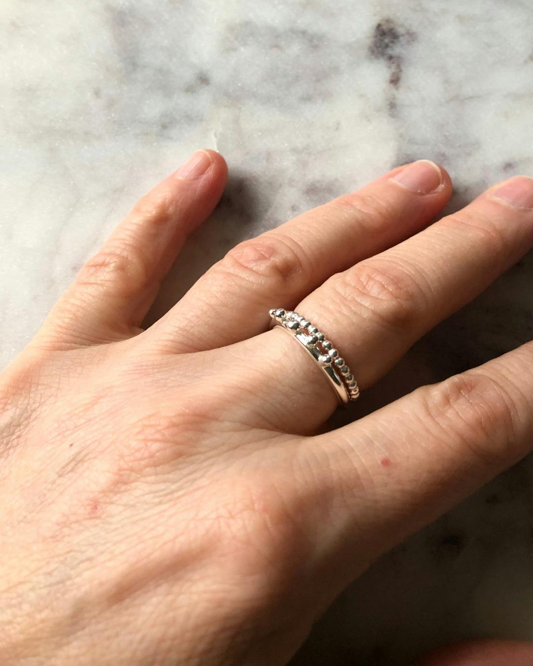 Handgjord kulformad ring i silver. Bilden visar ringen på en hand.
