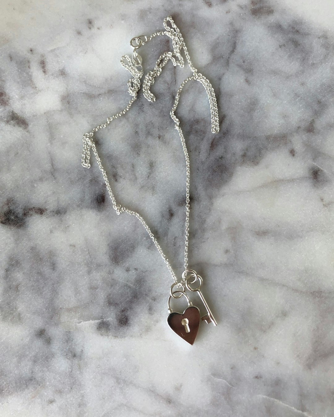 Handgjort halsband i återvunnet silver. I formen av ett hjärtformat hänglås och en nyckel.