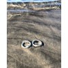 Kraftig oregelbunden ring av silver. Handtillverkad. Två ringar ligger på strand.