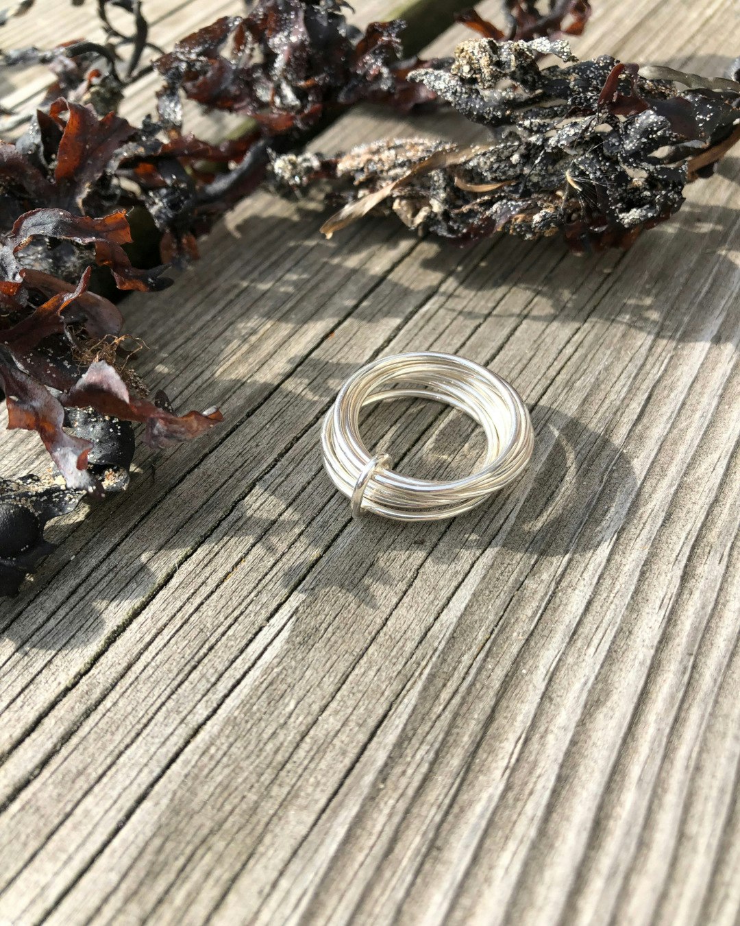 Handgjord ring med flera tunna silverringar, ihopsatta med en liten silverögla.