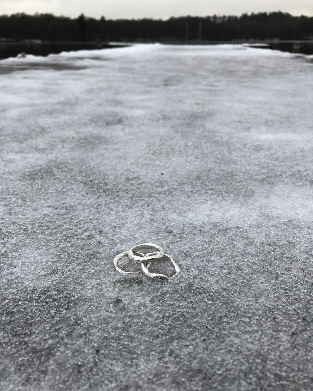 Enkla silverringar i återvunnet silver. Smält och rå yta. Ligger på is.