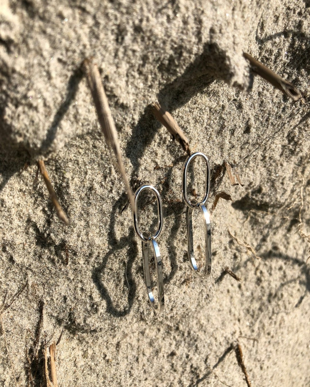 Örhängen i återvunnet silver med två länkar. På stranden.