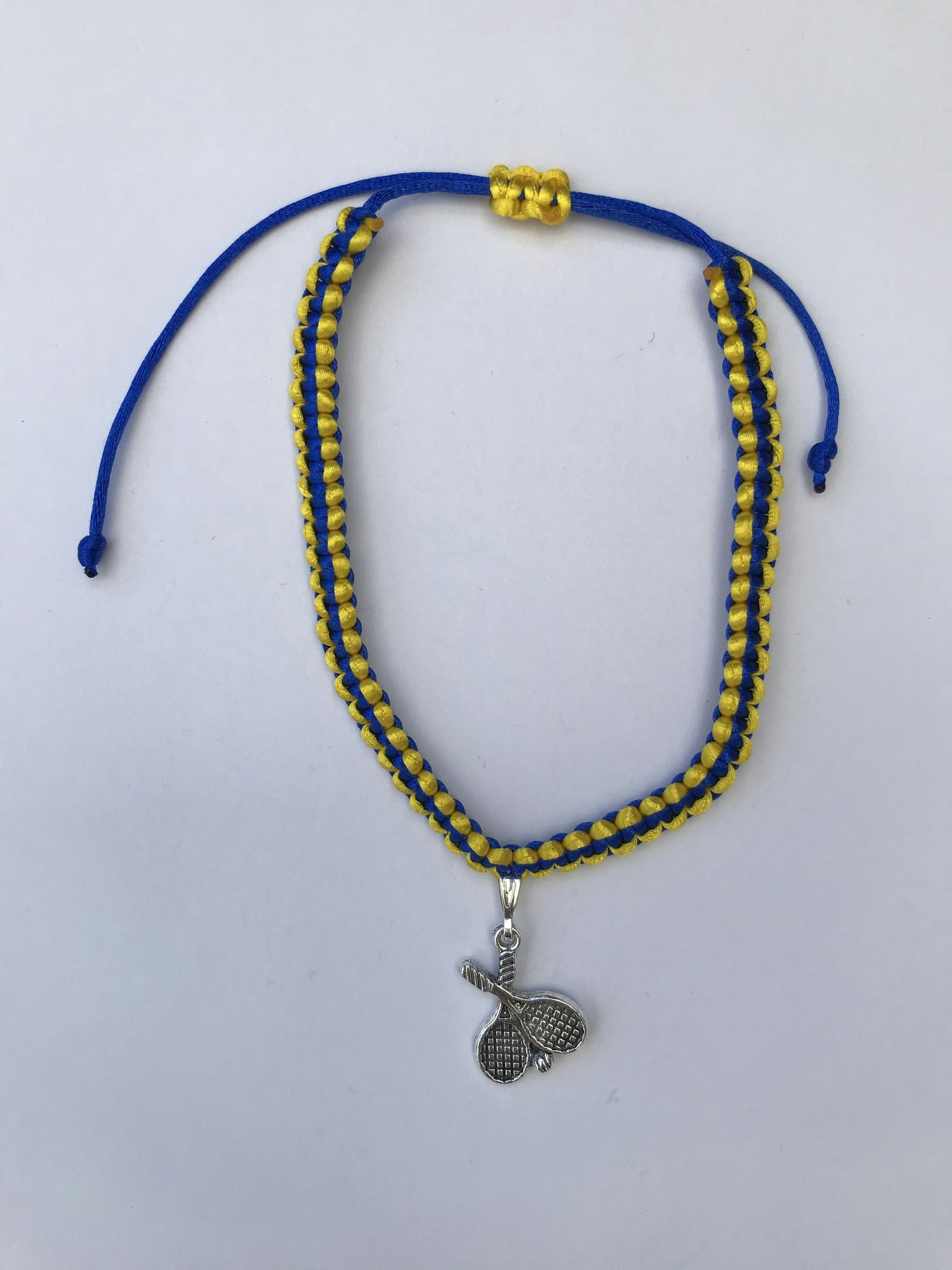 Makraméarmband i blått och gult med padel berlock i antikfärgat silver
