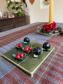 Tre i rad spel i keramik med blåbär och lingon