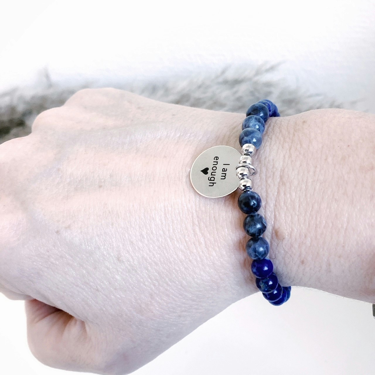 Budskapsarmbandet Self power med stenen Lapis lazuli och sodalit med en graverad textberlock i rostfitt stål och hur armbandet sitter på armen.