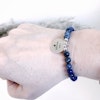 Budskapsarmbandet Self power med stenen Lapis lazuli och sodalit med en graverad textberlock i rostfitt stål och hur armbandet sitter på armen.
