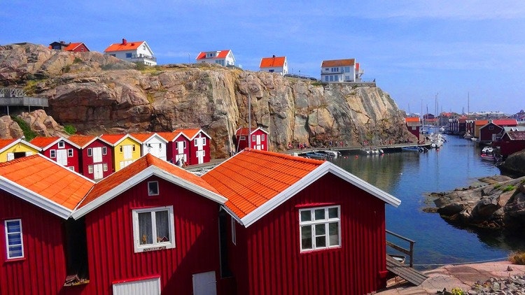 Röda byggnaden vid havet nedanför backen. Illustrerar strandskyddsdispens på grund av väl avskilt genom bebyggelse.