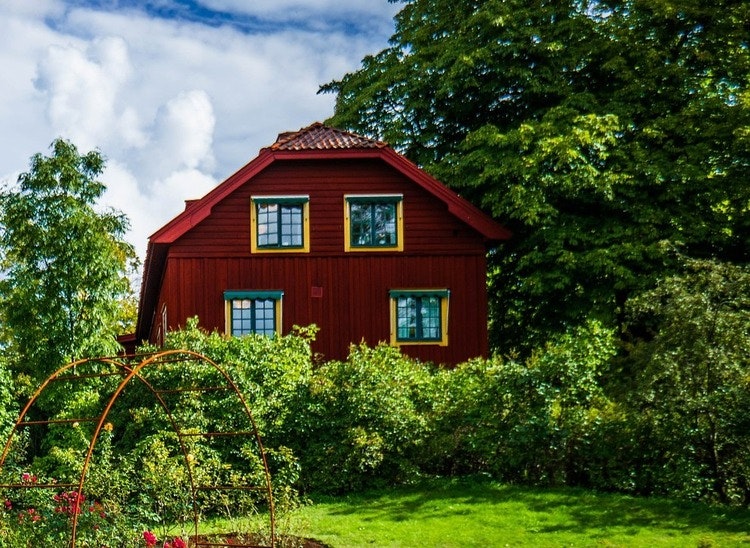 Falurött hus med trädgård framför, visar förhandsbesked utanför detaljplan.