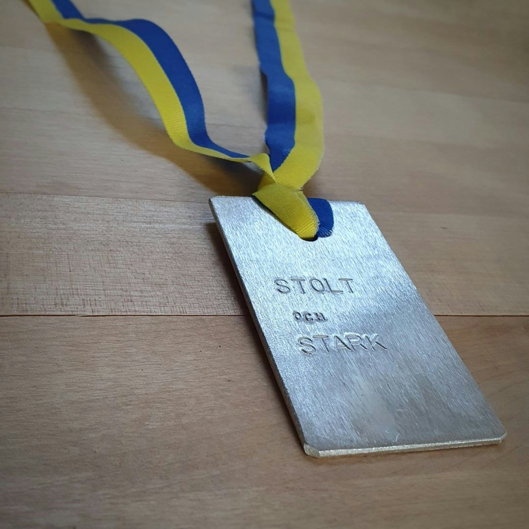 Fin text i blågult band att hänga runt halsen på student.
