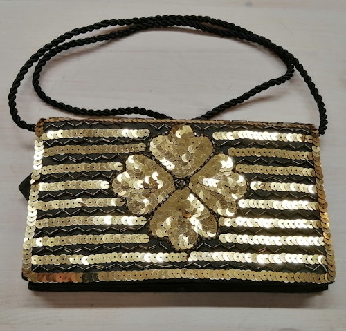 Second hand handväska kuvertväska med svarta och guldf paljetter fyrklöver