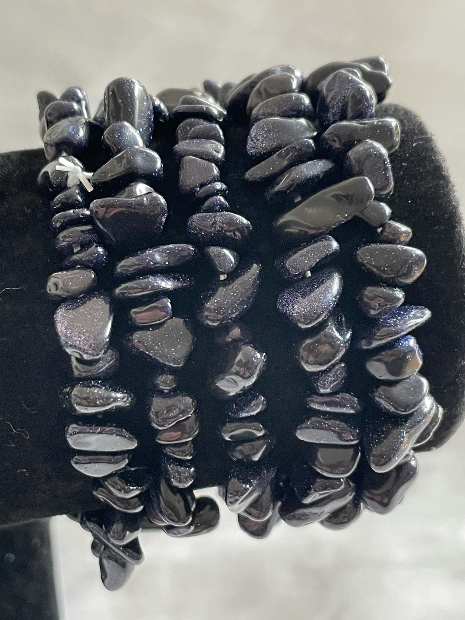 på bilden visas flera armband med blåglittriga stenar