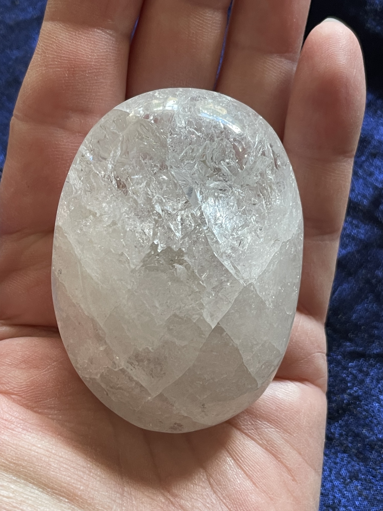På bilden visas krackelerad Bergskristall i Palmstone liggande i en hand