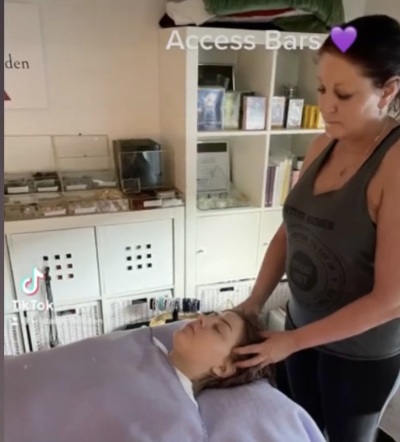 Bilden visar en kvinna som gör en behandling som kallas Access bars