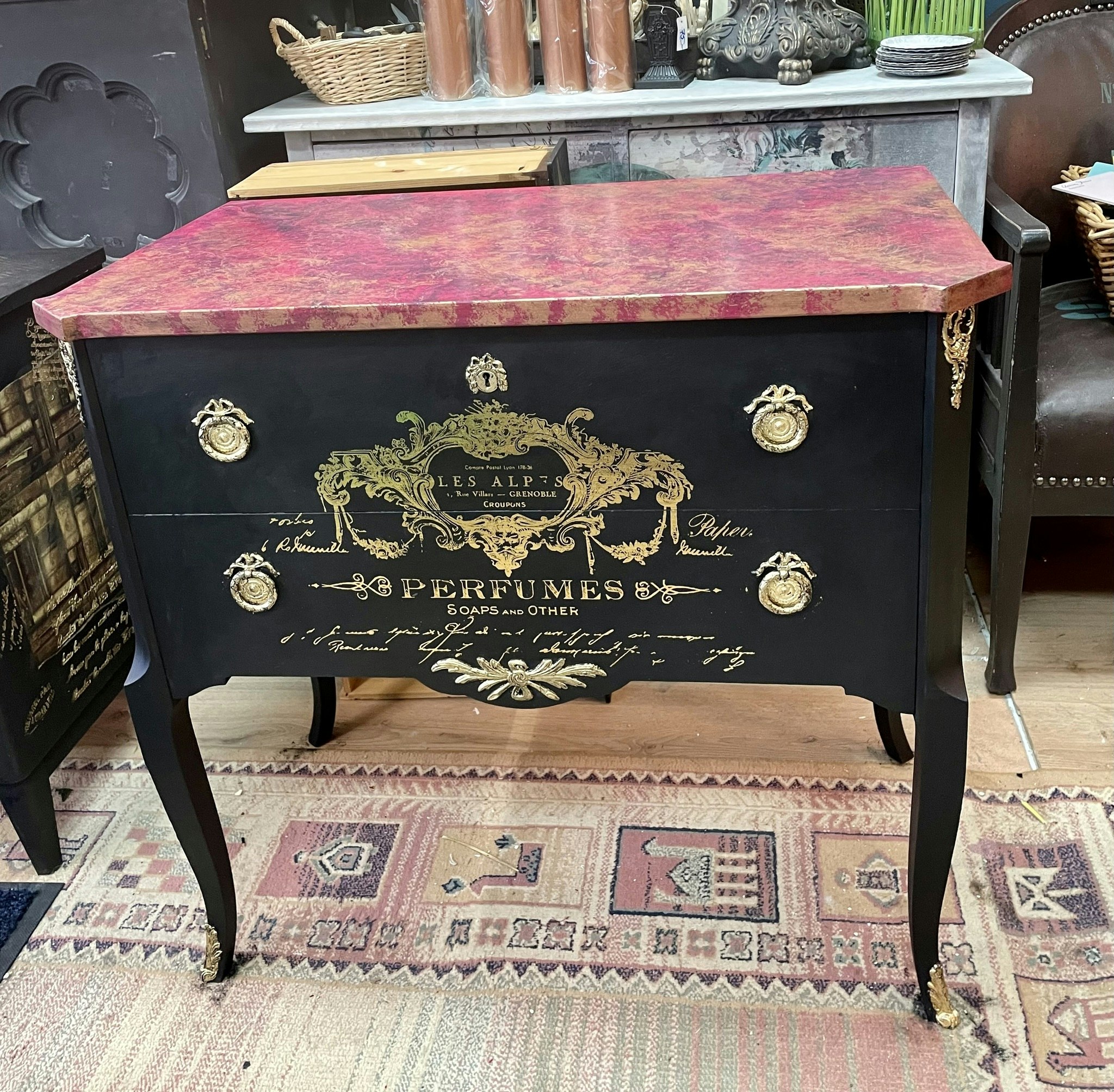 Svart byrå med rosa marmor.