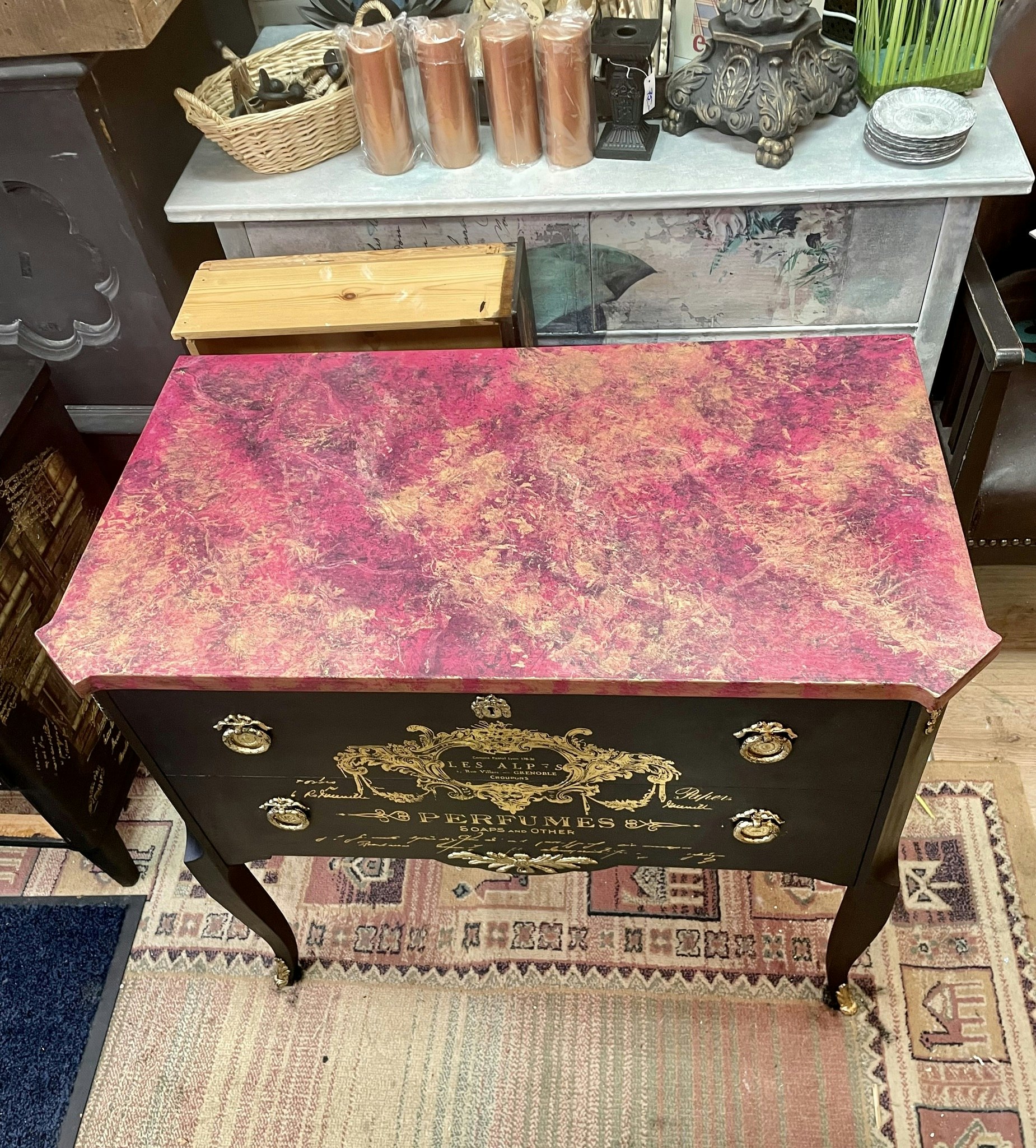 Svart byrå med rosa marmor.