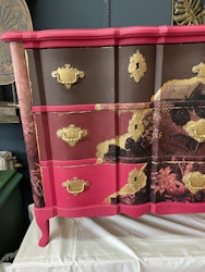 Byrå läckert målad i mörkrosa brunt och vinröd med detaljer i guld.