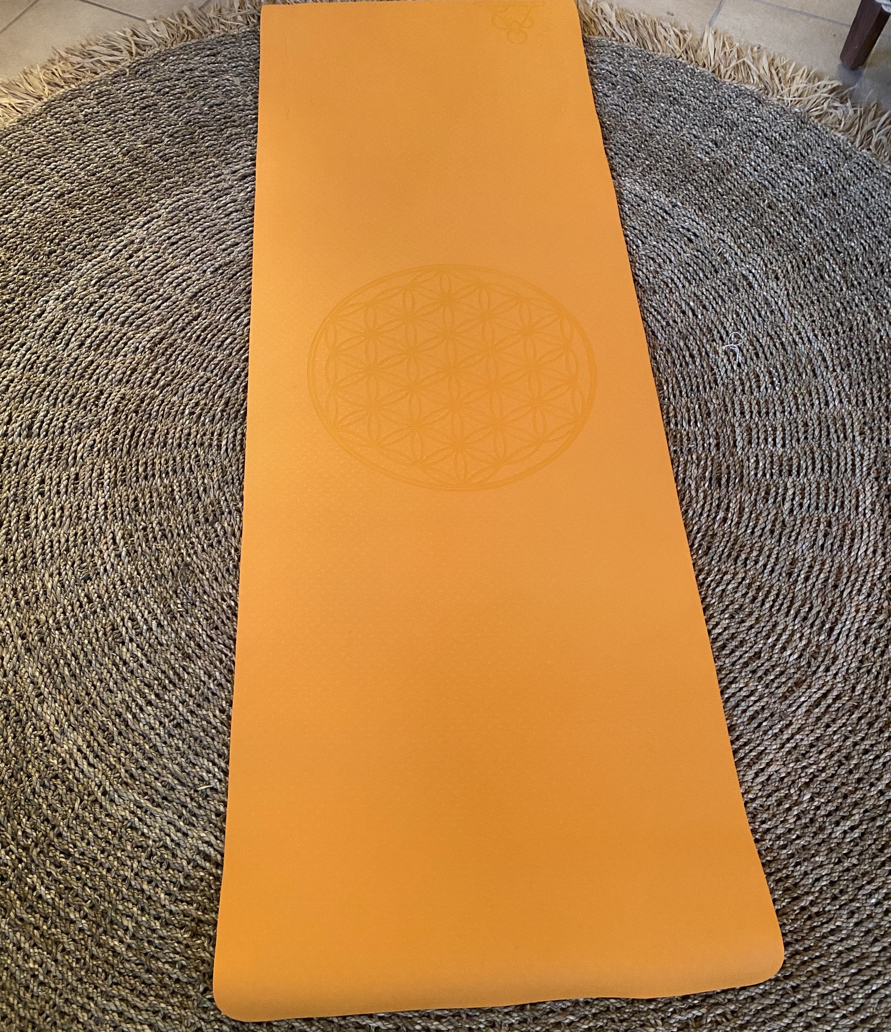 Orange yogamatta med livets blomma