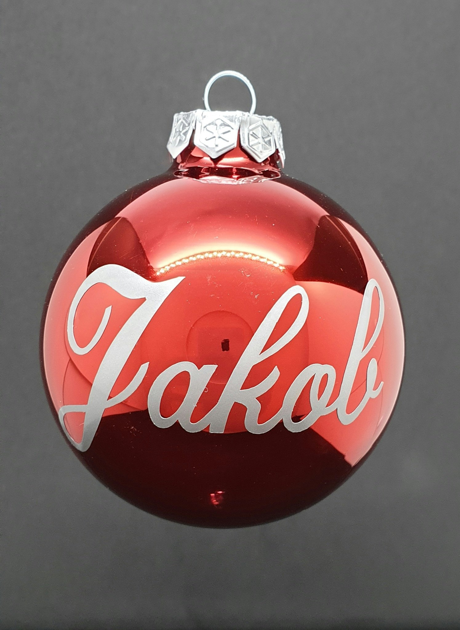 Røde julekuler med sølvskrift.
