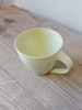 Frida Nilsson Keramik Höganäs Handgjord keramik kaffekopp med öra vaniljgul vanilj pastell drejad