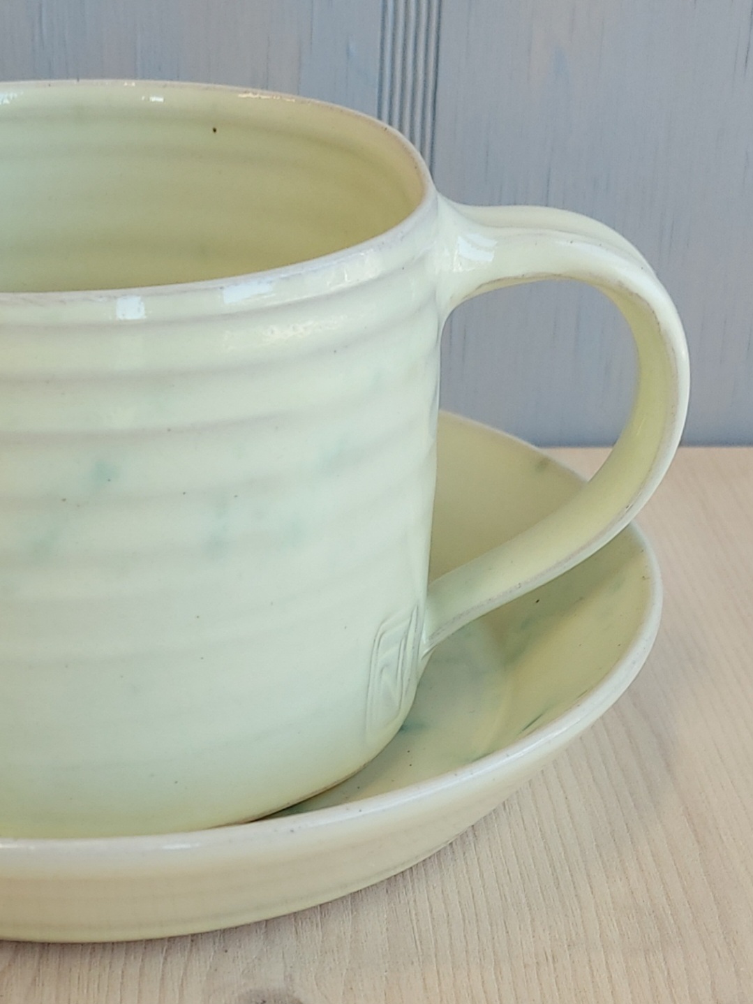 Frida Nilsson Keramik Handdrejad kaffekopp med fat stengodslera vaniljgul med stänk