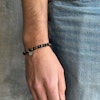Brunt och svart beadsarmband för män på arm