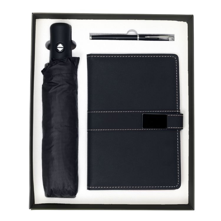 En svart presentbox med anteckningsbok, penna och paraply.