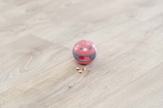 En röd snackboll med godis som ligger framför den.