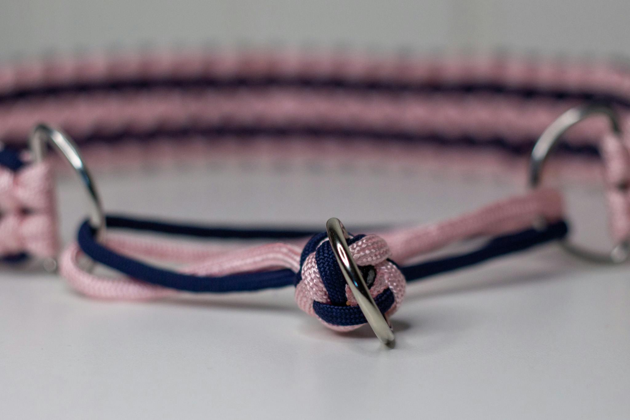 Handflätat halsband i rosa och marinblå.