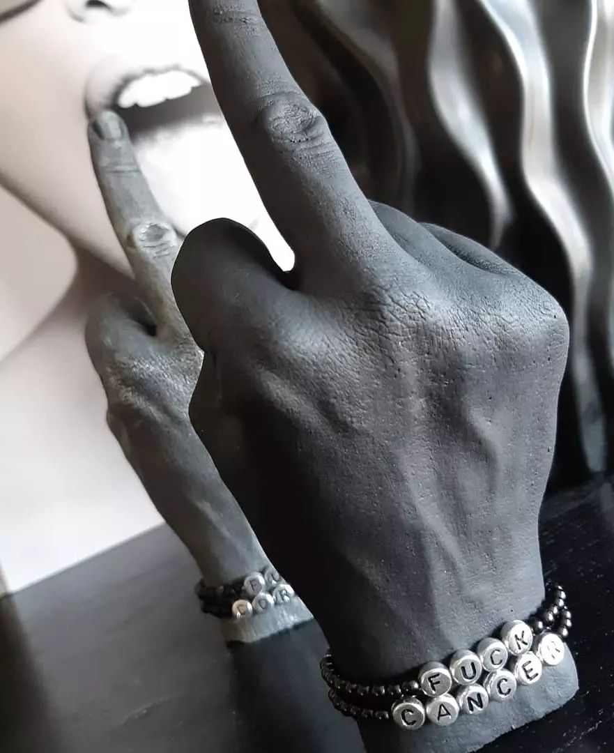 Fuck u hand med röd nagel & armband  FUCK CANCER