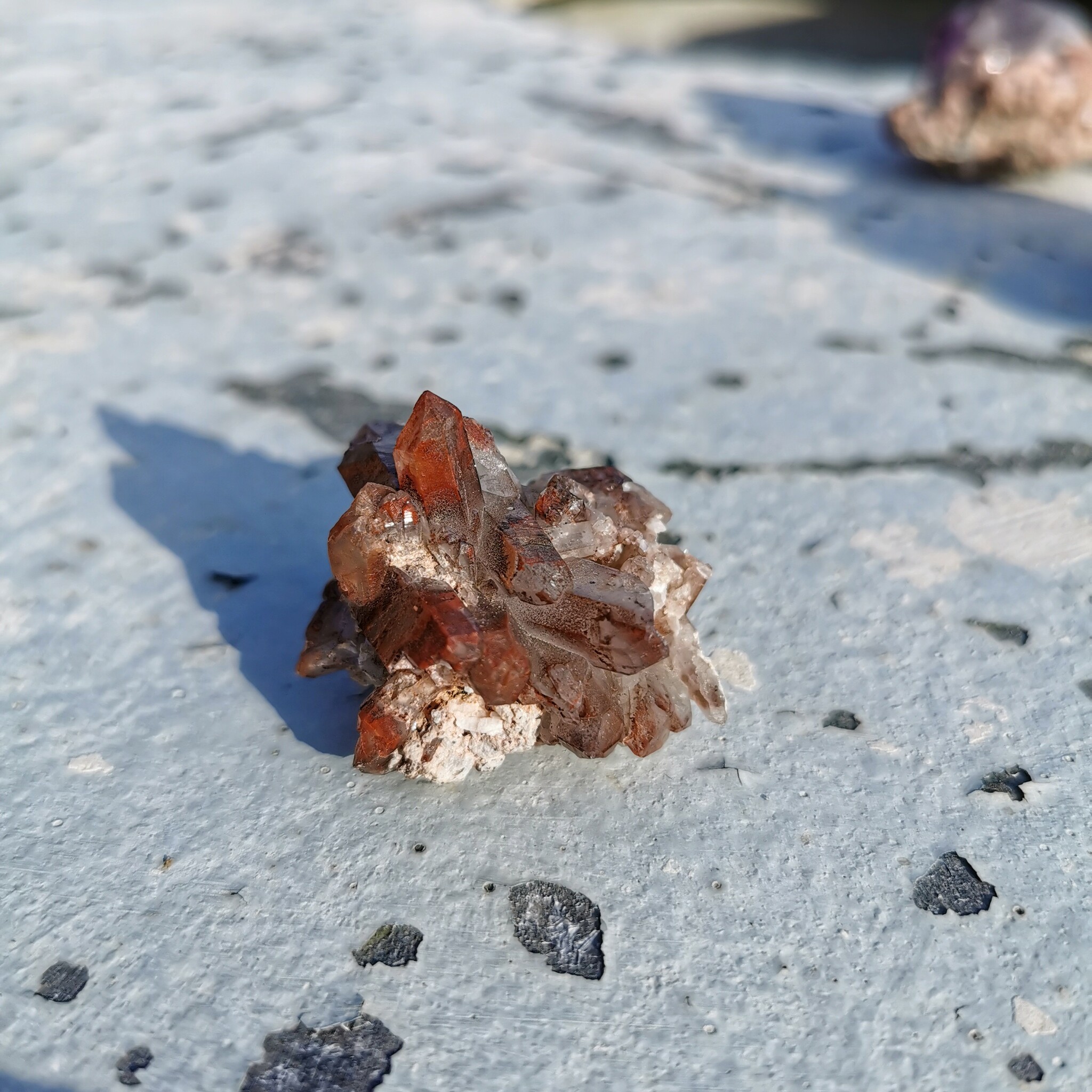 Litet bergkristall kluster med röda inklusioner